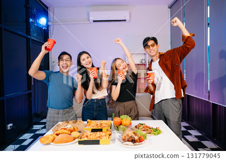 Celebration with friends enjoying food, drinks, and laughter at a lively house party. Perfect for themes of joy Celebration with friends enjoying food, drinks, and laughter at a lively house party. Perfect for themes of joy 131779045