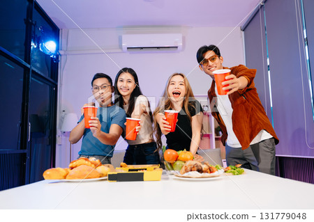 Celebration with friends enjoying food, drinks, and laughter at a lively house party. Perfect for themes of joy 131779048