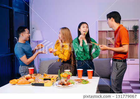Celebration with friends enjoying food, drinks, and laughter at a lively house party. Perfect for themes of joy Celebration with friends enjoying food, drinks, and laughter at a lively house party. Perfect for themes of joy 131779067
