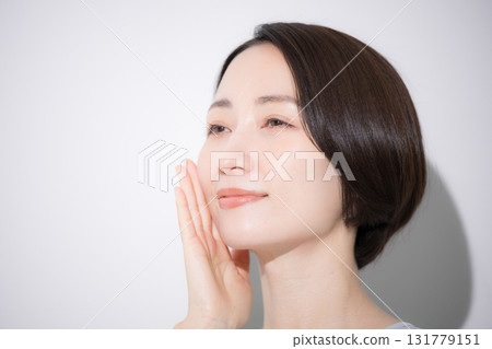 Close-up of a smiling woman with her hand on her cheek - image of beauty and other aspects Close-up of a smiling woman with her hand on her cheek - image of beauty and other aspects 131779151