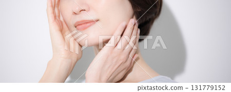 Close-up of a smiling woman with her hand on her cheek. Image of beauty and other aspects. Banner without face. Close-up of a smiling woman with her hand on her cheek. Image of beauty and other aspects. Banner without face. 131779152