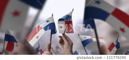 Panama flags in their hands on a blurred urban background Panama flags in their hands on a blurred urban background 131779290