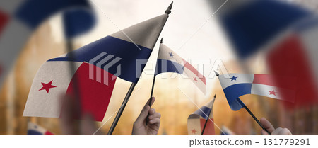 Panama flags in their hands on a blurred urban background Panama flags in their hands on a blurred urban background 131779291