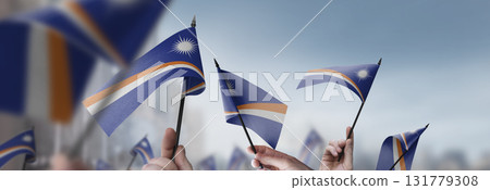 Marshall flags in their hands on a blurred urban background 131779308