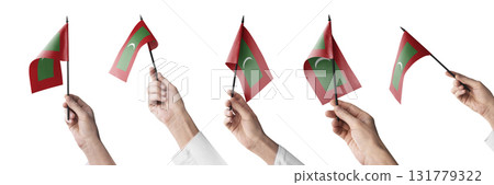 The Maldives flag in hand in different angles on a white background 131779322
