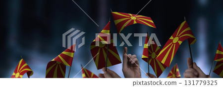 Macedonia flags in their hands on a blurred urban background 131779325