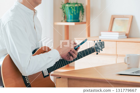 Hand of a man playing the guitar 131779667