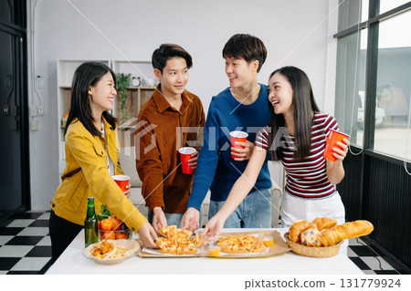 Group of Young Asian friend having, enjoy evening party together at home. Attractive young man and woman having fun, eating food, celebrate at home Group of Young Asian friend having, enjoy evening party together at home. Attractive young man and woman having fun, eating food, celebrate at home 131779924
