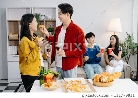 Group of Young Asian friend having, enjoy evening party together at home. Attractive young man and woman having fun, eating food, celebrate at home 131779931