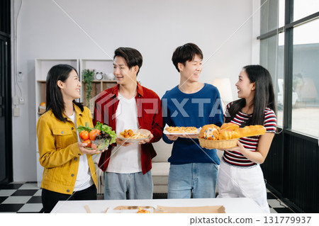 Group of Young Asian friend having, enjoy evening party together at home. Attractive young man and woman having fun, eating food, celebrate at home 131779937