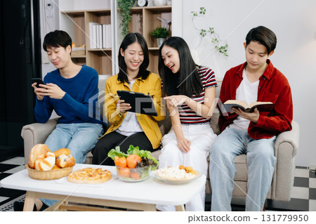 Group of Young Asian friend having, enjoy evening party together at home. Attractive young man and woman having fun, eating food, celebrate at home 131779950