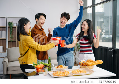 Group of Young Asian friend having, enjoy evening party together at home. Attractive young man and woman having fun, eating food, celebrate at home Group of Young Asian friend having, enjoy evening party together at home. Attractive young man and woman having fun, eating food, celebrate at home 131780049