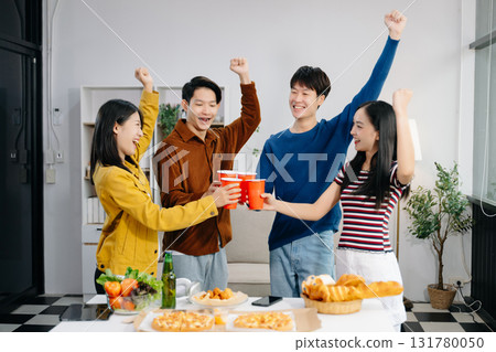 Group of Young Asian friend having, enjoy evening party together at home. Attractive young man and woman having fun, eating food, celebrate at home Group of Young Asian friend having, enjoy evening party together at home. Attractive young man and woman having fun, eating food, celebrate at home 131780050