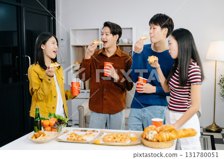 Group of Young Asian friend having, enjoy evening party together at home. Attractive young man and woman having fun, eating food, celebrate at home Group of Young Asian friend having, enjoy evening party together at home. Attractive young man and woman having fun, eating food, celebrate at home 131780051