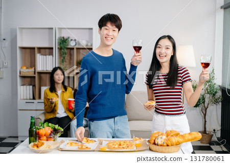 Group of Young Asian friend having, enjoy evening party together at home. Attractive young man and woman having fun, eating food, celebrate at home 131780061