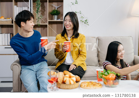 Group of Young Asian friend having, enjoy evening party together at home. Attractive young man and woman having fun, eating food, celebrate at home Group of Young Asian friend having, enjoy evening party together at home. Attractive young man and woman having fun, eating food, celebrate at home 131780138