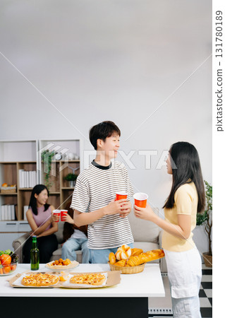 Group of Young Asian friend having, enjoy evening party together at home. Attractive young man and woman having fun, eating food, celebrate at home 131780189