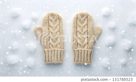 Cozy knitted mittens placed on a snowy backdrop during a winter day 131780523