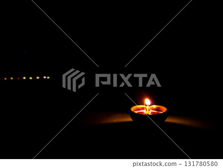 Single Clay Oil Lamp Glowing in Darkness Single Clay Oil Lamp Glowing in Darkness 131780580