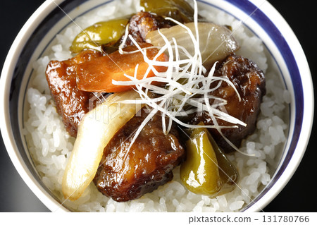 Sweet and sour pork bowl with black vinegar photographed against a black background 131780766