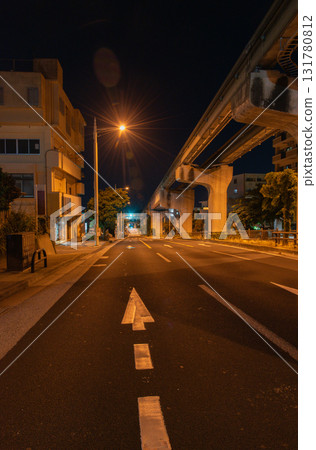 Monorail rails and roads late at night under bright orange street lights Monorail rails and roads late at night under bright orange street lights 131780812
