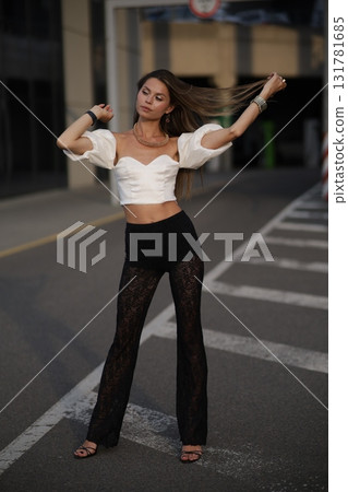 Woman posing on the road wearing fashionable clothes Woman posing on the road wearing fashionable clothes 131781685