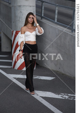 Woman posing on the road wearing fashionable clothes 131781821