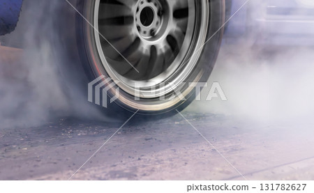 Smoke on wheel of drag racing car at starting line. 131782627