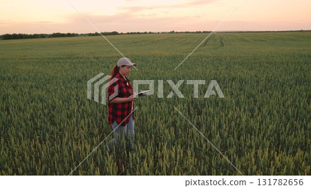 Agriculture, Early evening on the farm, Woman with technology, Exploring wheat fields, Sustainable food production, Modern farming solutions, Checking field conditions, Innovative agronomist, Rural Agriculture, Early evening on the farm, Woman with technology, Exploring wheat fields, Sustainable food production, Modern farming solutions, Checking field conditions, Innovative agronomist, Rural 131782656