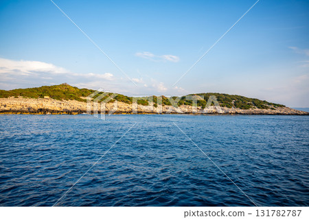 Uninhabited islands of the Lastovo National Park surrounded by calm sea in Croatia. Nature reserve, remote landscape and Mediterranean summer escape Uninhabited islands of the Lastovo National Park surrounded by calm sea in Croatia. Nature reserve, remote landscape and Mediterranean summer escape 131782787