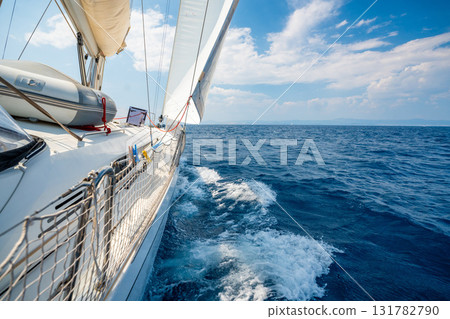 Side of a sailing yacht cutting through the sea with full sails near Croatia. Motion, freedom, sailing lifestyle and adventure on the open water. Side of a sailing yacht cutting through the sea with full sails near Croatia. Motion, freedom, sailing lifestyle and adventure on the open water. 131782790