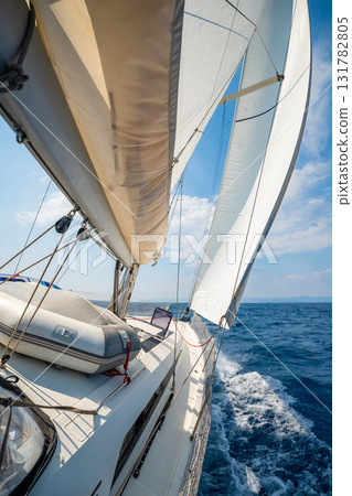 Side of a sailing yacht cutting through the sea with full sails near Croatia. Motion, freedom, sailing lifestyle and adventure on the open water. 131782805