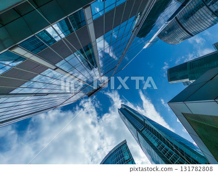 Skyscrapers reach toward the blue sky in a dynamic modern cityscape viewed from below Skyscrapers reach toward the blue sky in a dynamic modern cityscape viewed from below 131782808