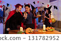 Dinner and group of people celebrating together at Halloween party. 131782952