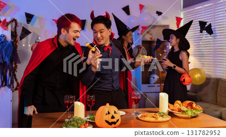 Dinner and group of people celebrating together at Halloween party. 131782952