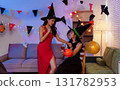 Dinner and group of people celebrating together at Halloween party. 131782953