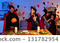 Dinner and group of people celebrating together at Halloween party. 131782954