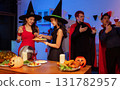 Dinner and group of people celebrating together at Halloween party. 131782957
