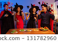 Dinner and group of people celebrating together at Halloween party. 131782960