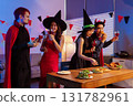 Dinner and group of people celebrating together at Halloween party. 131782961