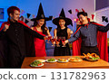 Dinner and group of people celebrating together at Halloween party. 131782963