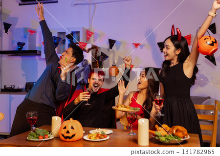 Dinner and group of people celebrating together at Halloween party. 131782965