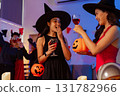 Dinner and group of people celebrating together at Halloween party. 131782966