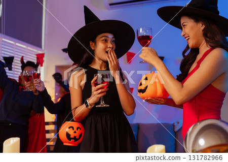 Dinner and group of people celebrating together at Halloween party. 131782966