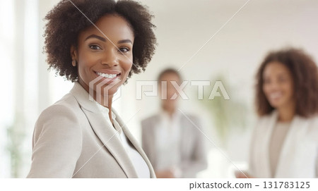 Smiling African American businesswoman in an office setting, professional team interaction 131783125