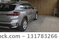 A modern silver BMW with sleek lines, a black roof, and distinctive LED taillights, is parked in a driveway. 131783266