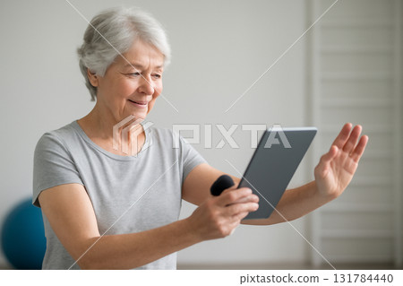 AI generated elderly Asian woman following AI-guided fitness exercises on a tablet in a gym. The focus is on health, technology, and active aging in a modern, uplifting environment. AI generated elderly Asian woman following AI-guided fitness exercises on a tablet in a gym. The focus is on health, technology, and active aging in a modern, uplifting environment. 131784440