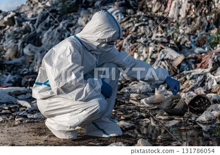 People in protective gear are inspecting trash at a landfill, taking steps to manage waste and reduce environmental pollution effectively People in protective gear are inspecting trash at a landfill, taking steps to manage waste and reduce environmental pollution effectively 131786054