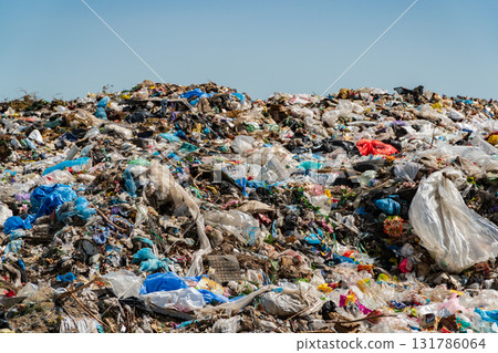 A sprawling landfill site overflowing with colorful plastic and other waste, contributing to pollution and ecological harm A sprawling landfill site overflowing with colorful plastic and other waste, contributing to pollution and ecological harm 131786064