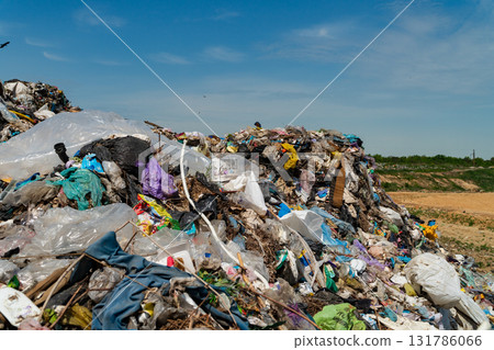 Trash accumulates in a landfill site, revealing the ongoing issue of waste management and environmental pollution under a clear sky Trash accumulates in a landfill site, revealing the ongoing issue of waste management and environmental pollution under a clear sky 131786066